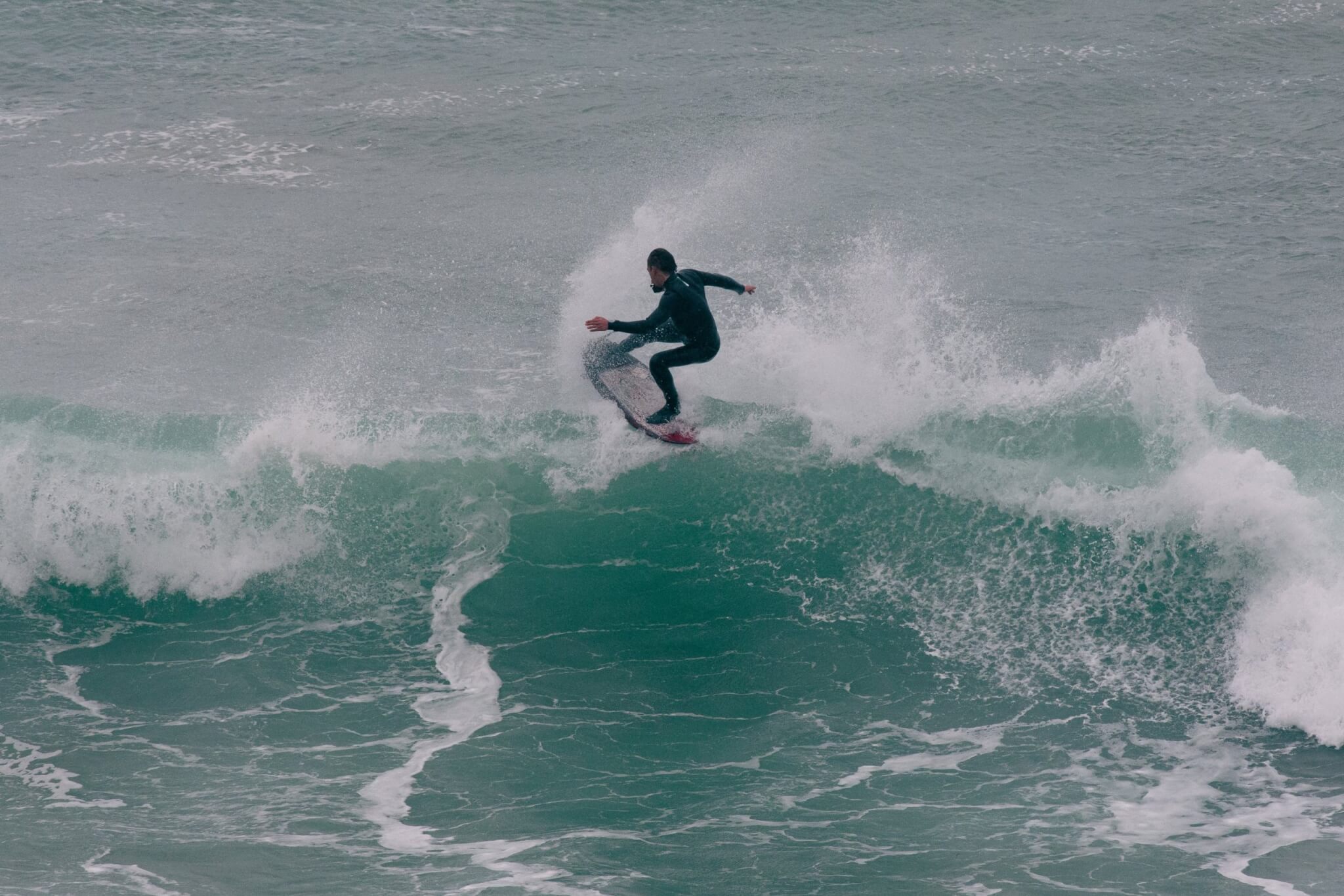 Surfer carving a wave off the Cornish coast
