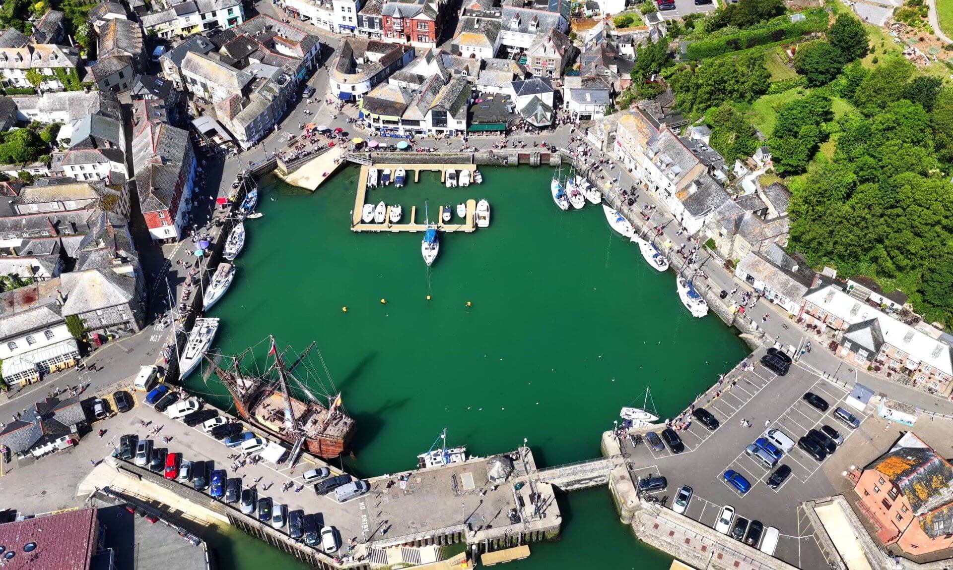 Aerial view of Padstow harbour on a sunny day with boats and visitors