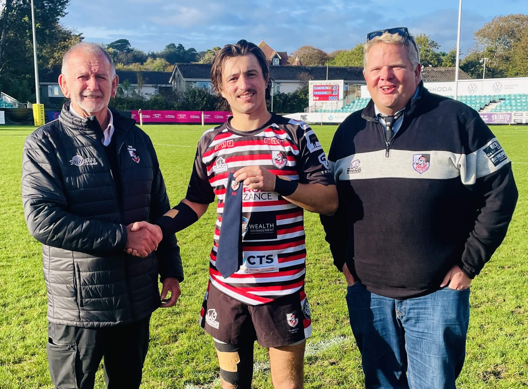 Dan Rhys Evans receives his 100 games tie from Pirates' President Phil Westren, with club Chairman Peter Whyte