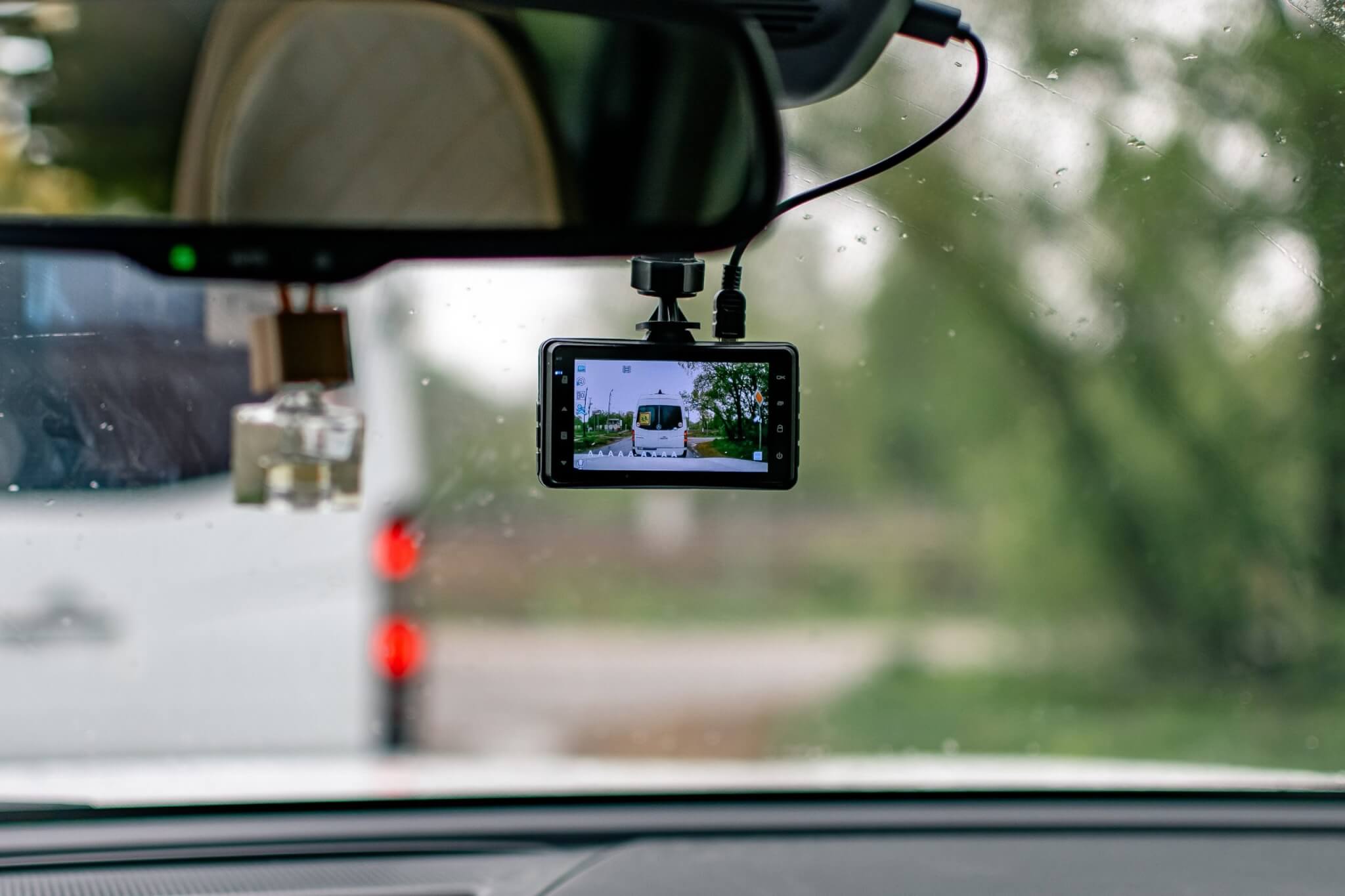 Dashcam mounted on a car windscreen in the rain