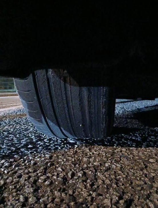 Close-up of a worn, defective car tyre on gravel