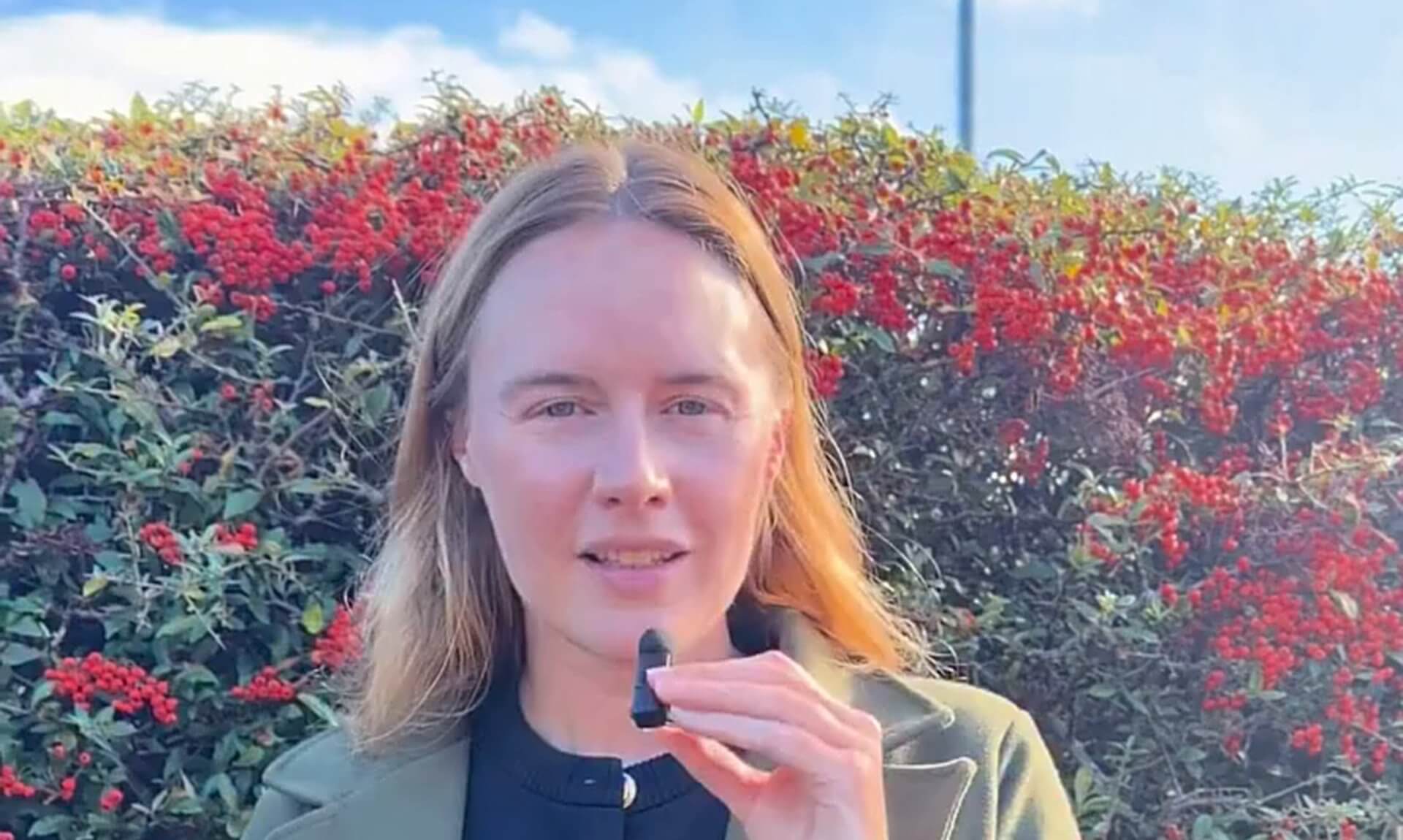 Anna Gelderd MP in front of a red berry hedge