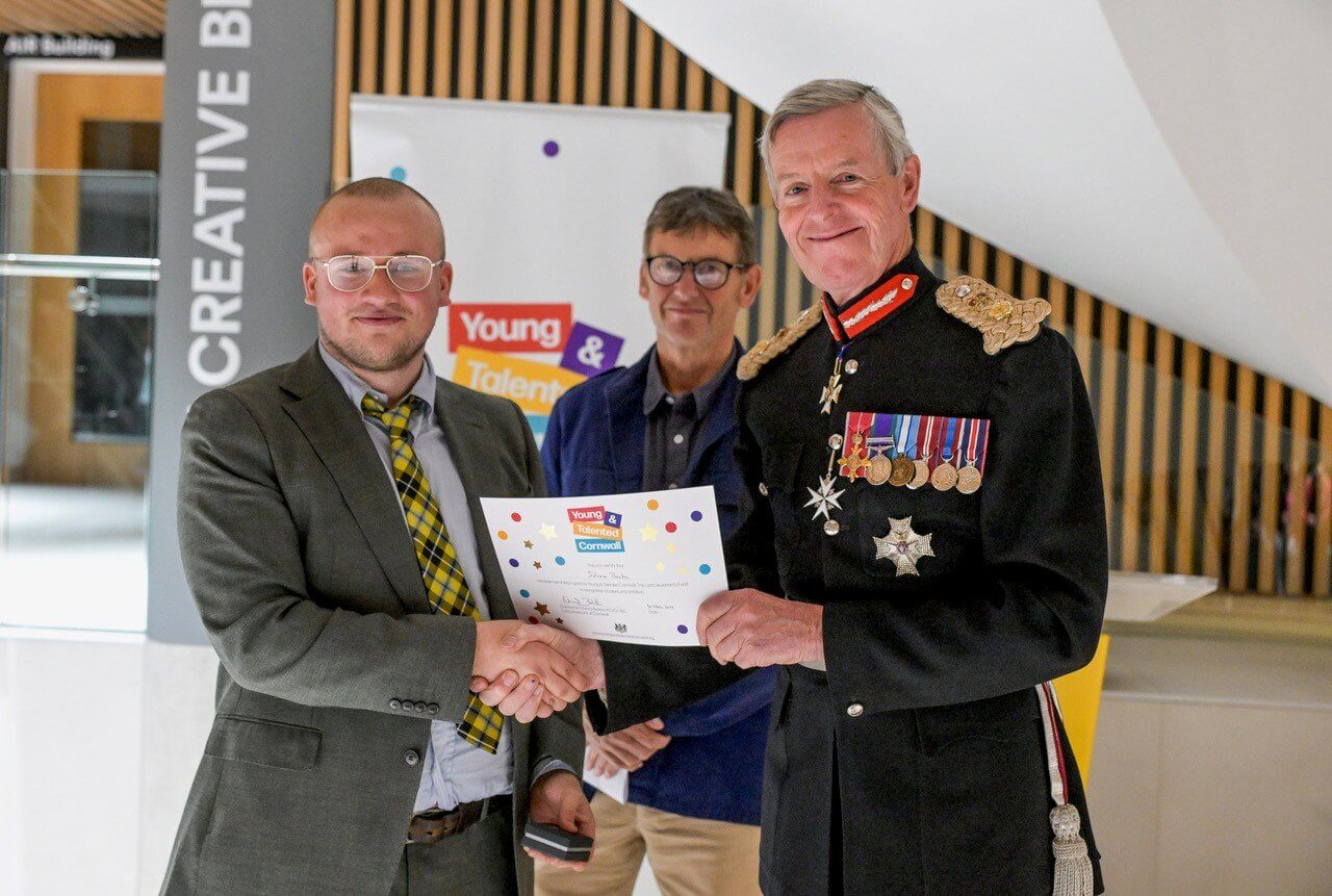 An award winner shaking hands with the Lord Lieutenant of Cornwall