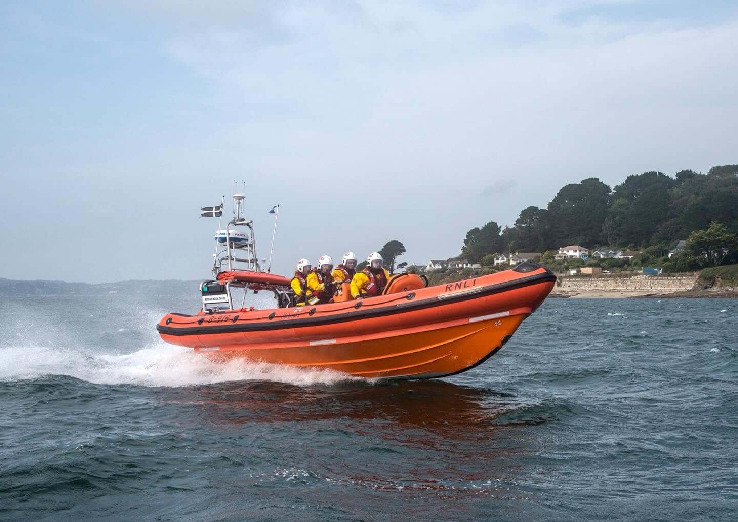 Falmouth RNLI Atlantic 85 inshore lifeboat at speed with four crew on board