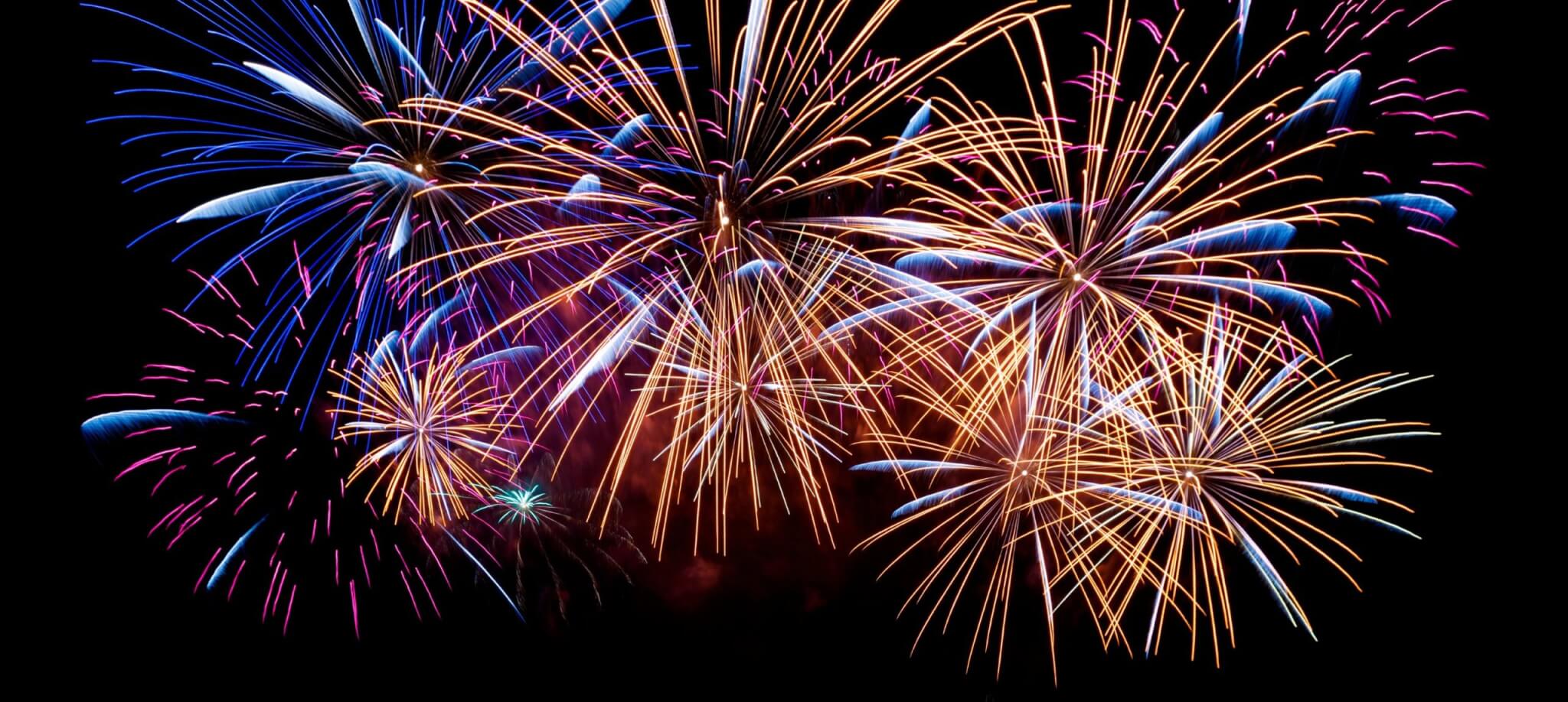 Blue, gold and pink fireworks filling the night sky