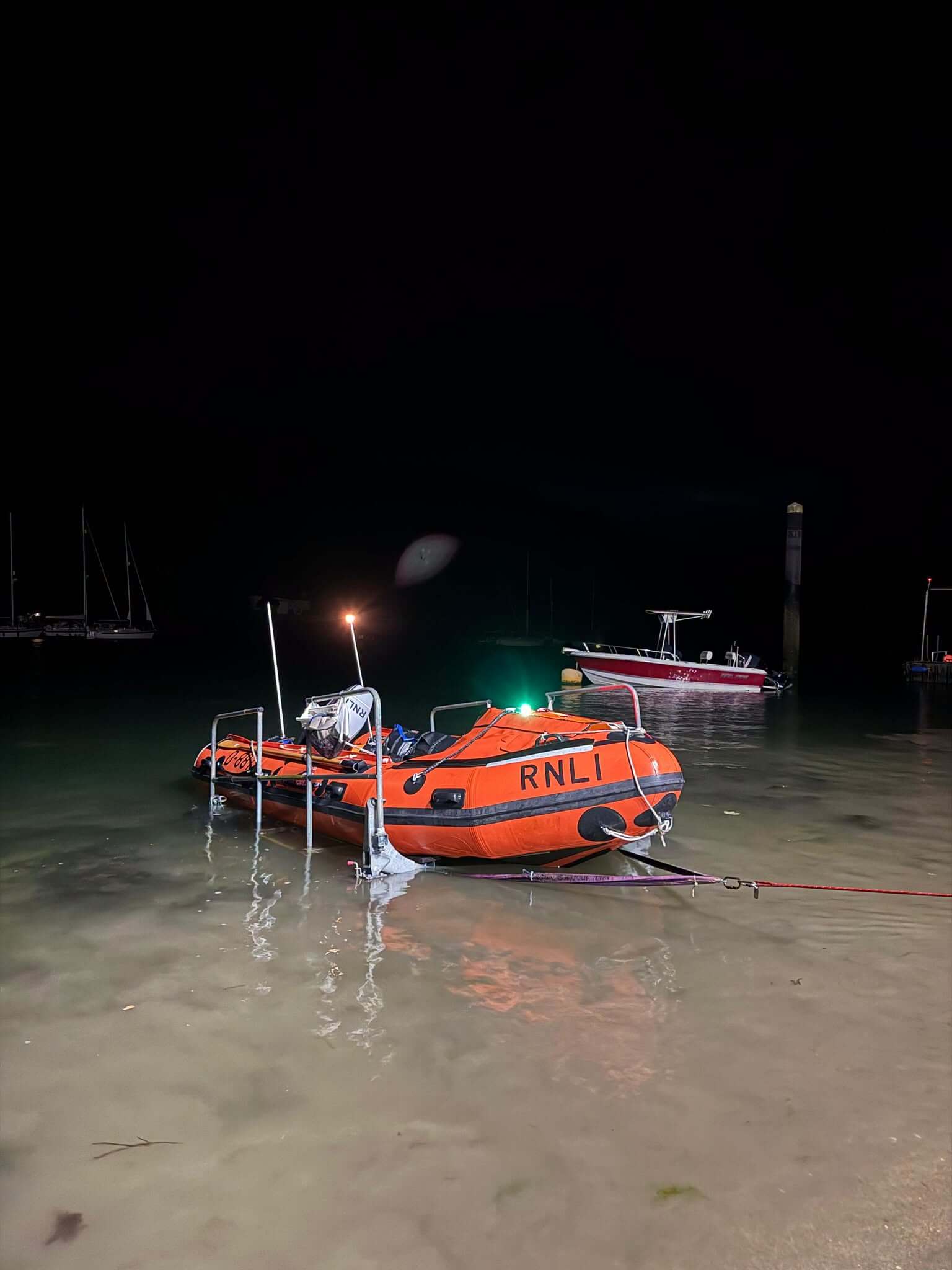 Fowey RNLI inshore lifeboat in the shallows at night
