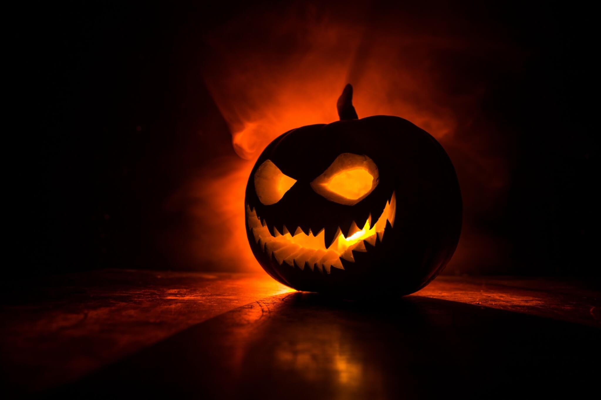 A carved jack-o-lantern pumpkin glowing orange in the dark