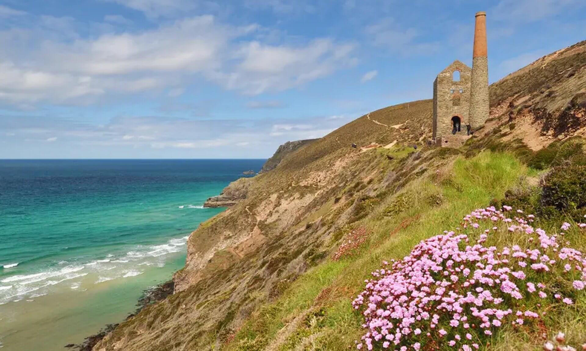 Engine house at Wheal Coates above the sea near St Agnes with sea pinks in the foreground