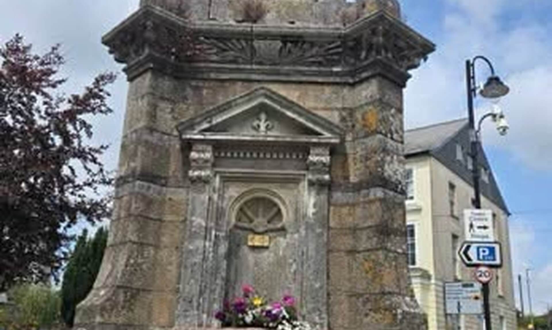The Fountain on Barras Street in Liskeard, a stone drinking fountain with flower planters