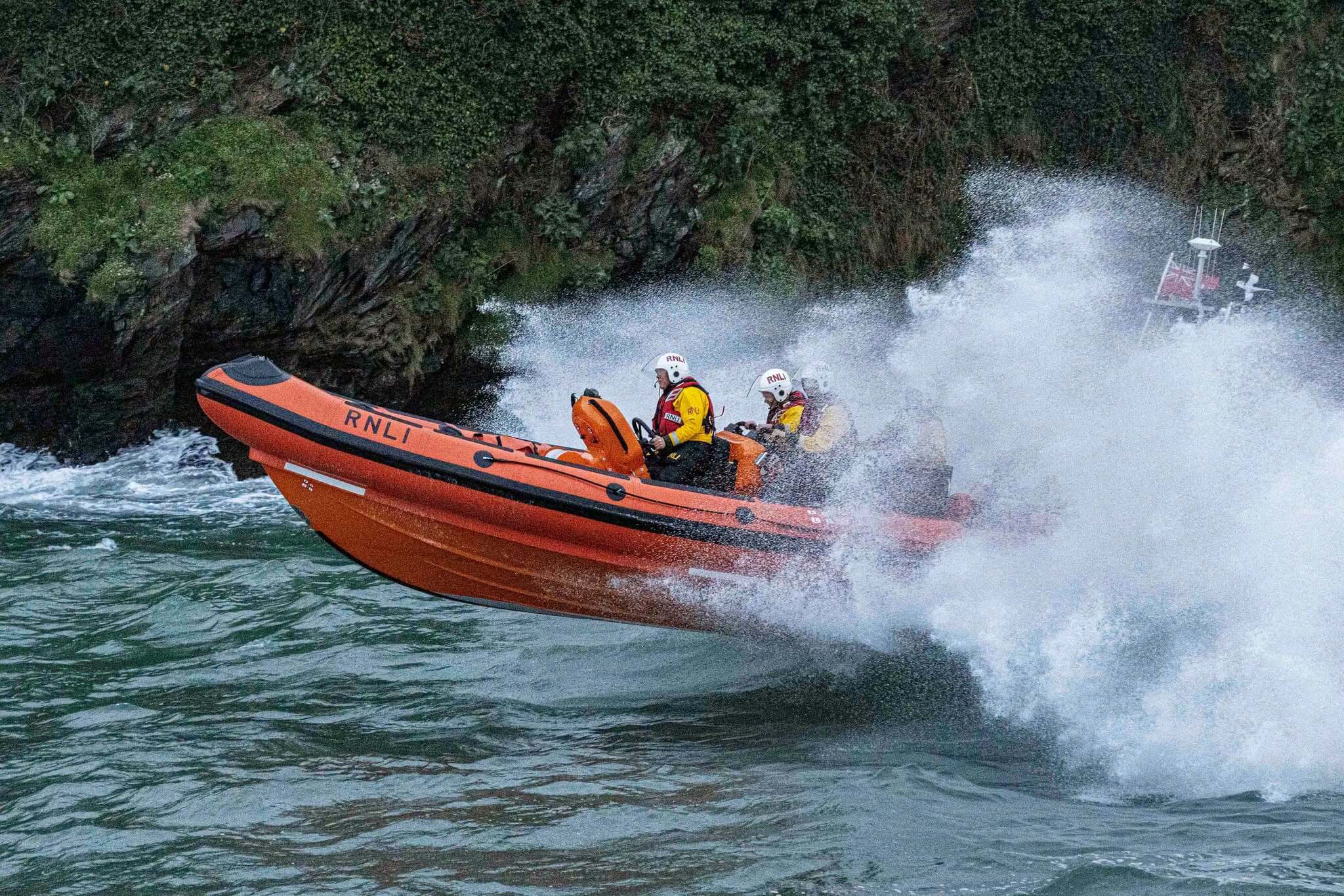 Looe RNLI Atlantic 85 lifeboat punching through spray in rough seas