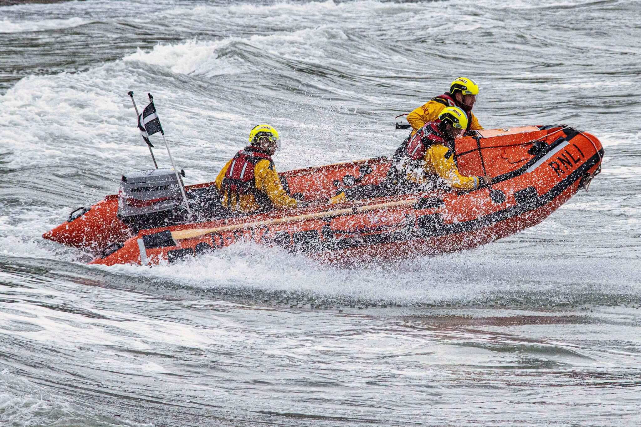 Looe RNLI D class lifeboat crew in rough water