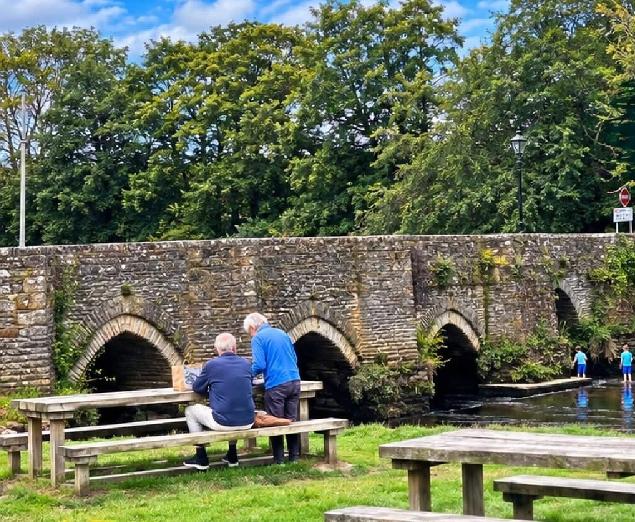 Picnic benches beside the stone bridge in Lostwithiel