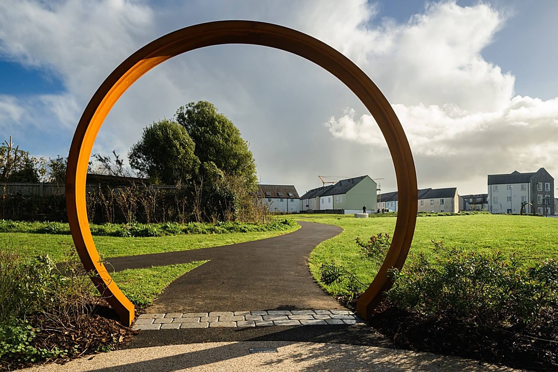 Weathering steel ring sculpture framing a path at Lowarth Holman, Camborne