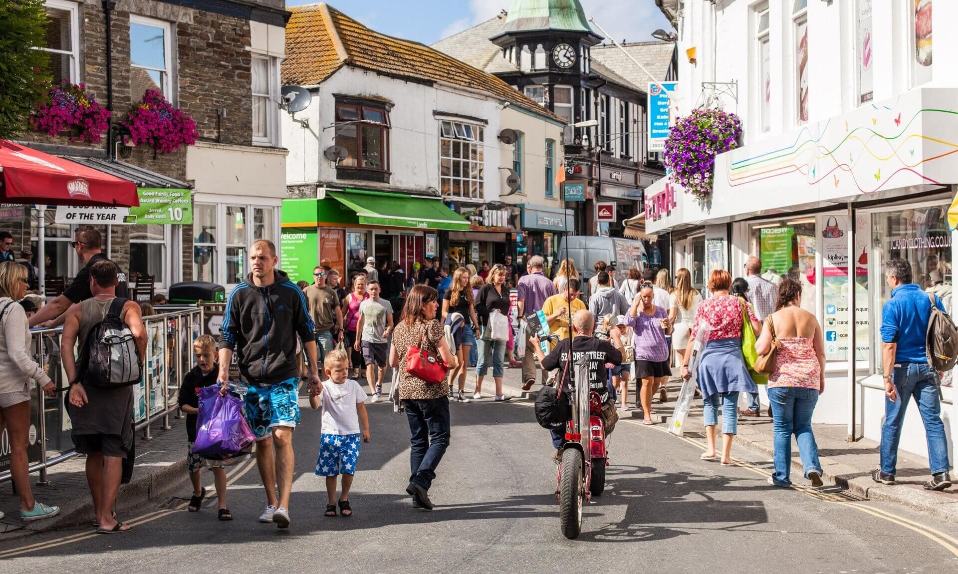 Shoppers and visitors on a busy street in Newquay town centre