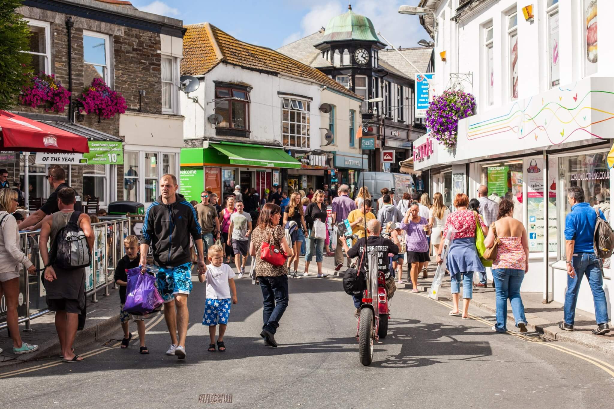 Shoppers and visitors on a busy street in Newquay town centre