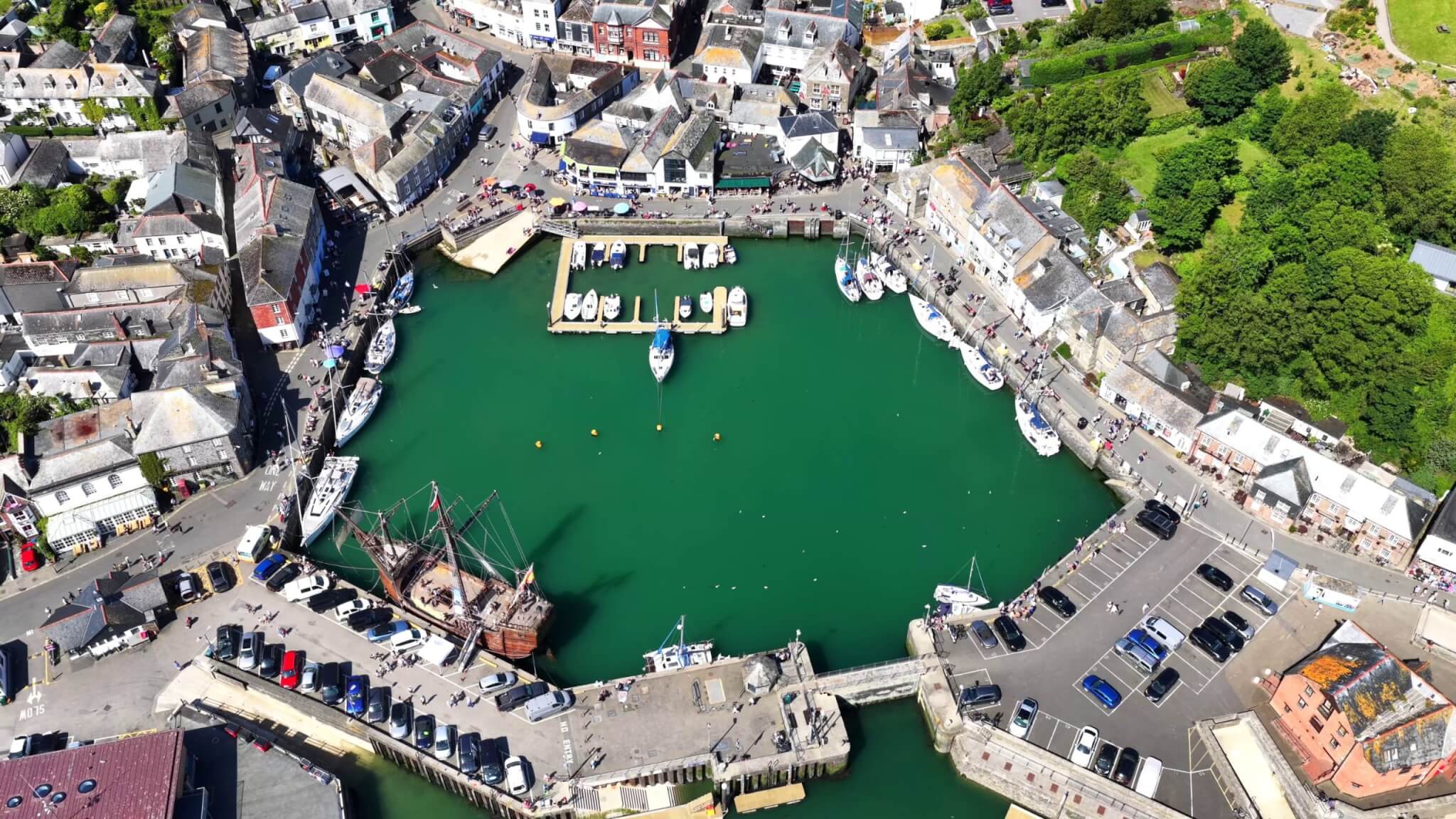 Aerial view of Padstow harbour on a sunny day with boats and visitors
