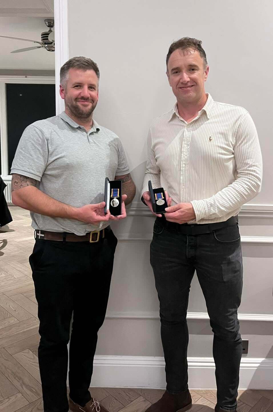Padstow RNLI volunteer crew Tom Norfolk and Ross McBurnie holding their 20 year long service medals