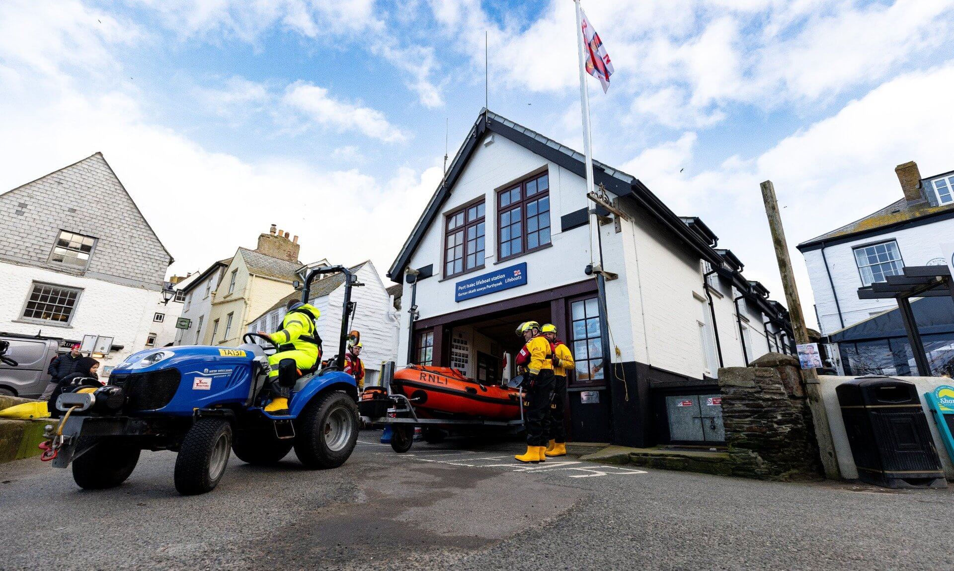 Port Isaac RNLI crew bringing the D-class lifeboat out of the station by tractor