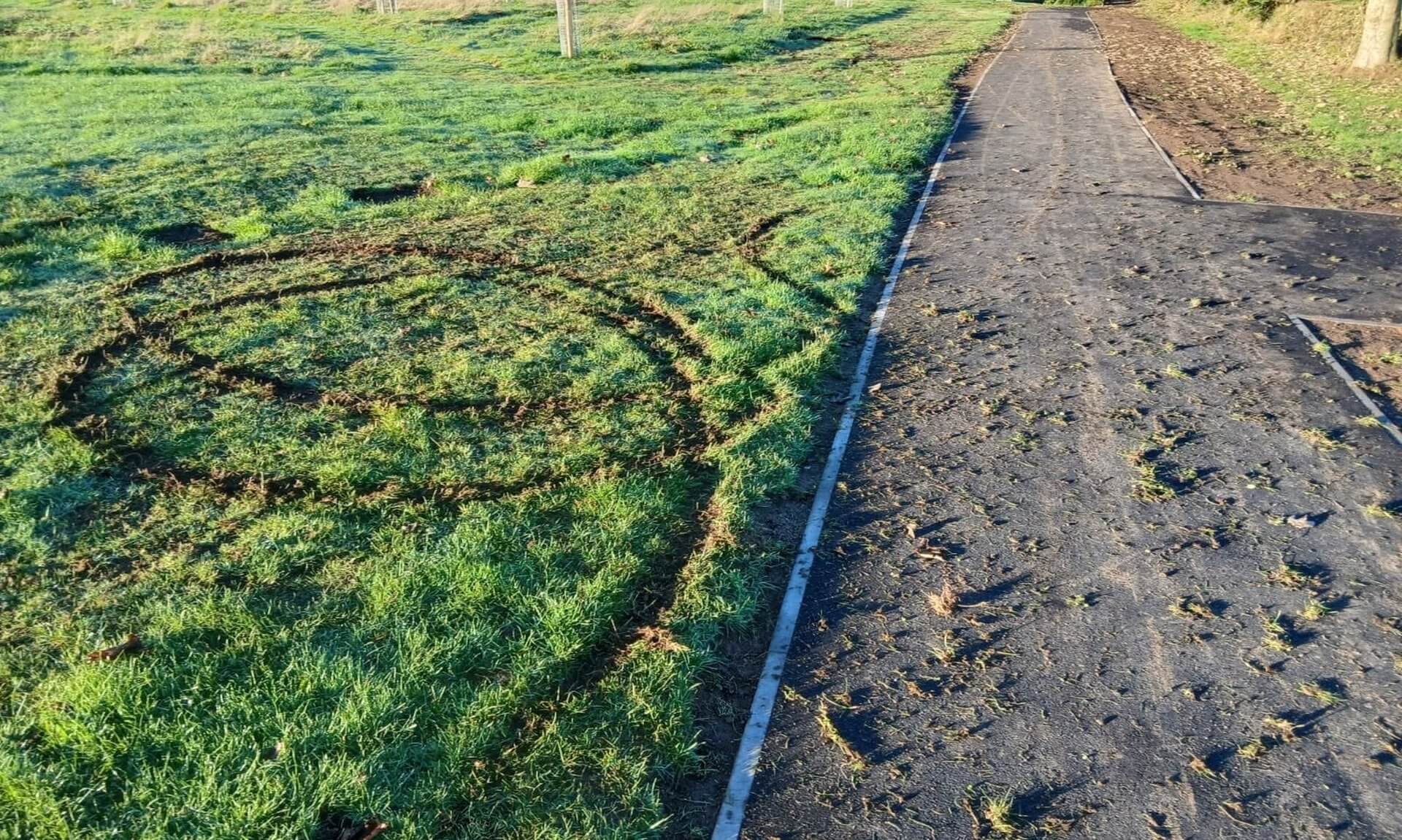Tyre tracks cut into the grass beside a new pathway at East End Park in Redruth
