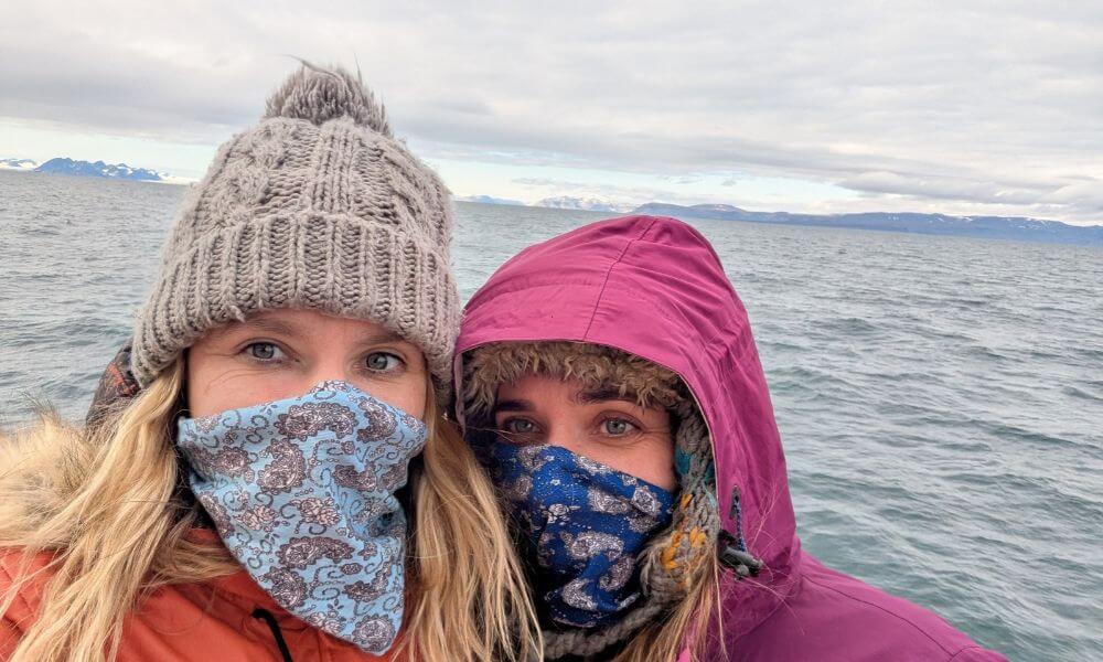Two sisters wrapped up against the cold at sea in the Arctic