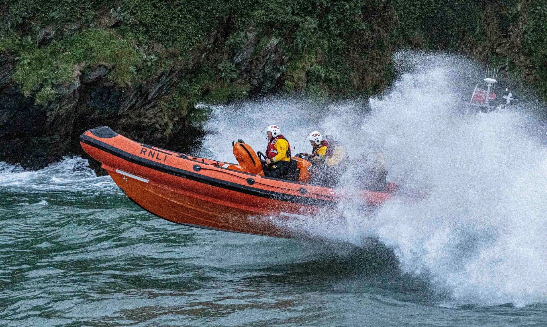 Looe RNLI Atlantic 85 lifeboat punching through spray in rough seas