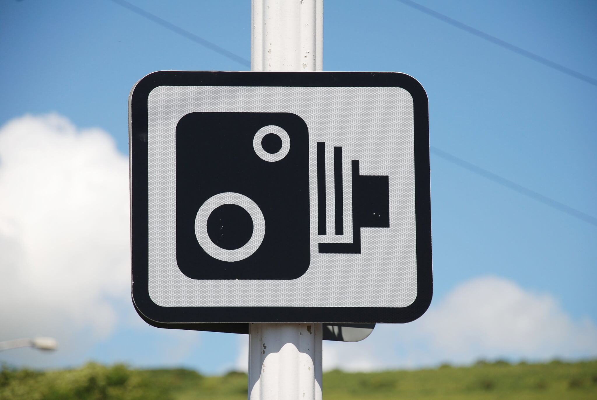 Speed camera road sign against a blue sky