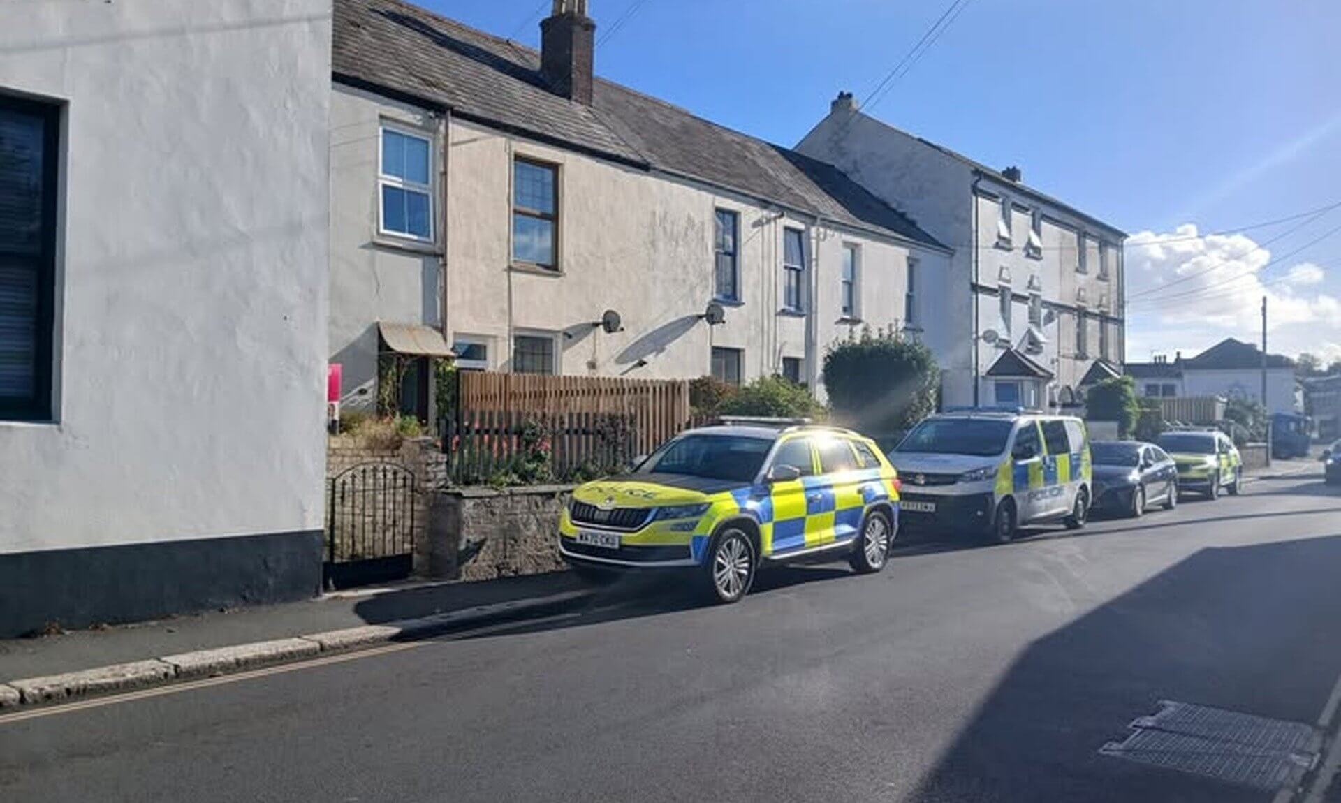 Police vehicles parked on a street in St Austell