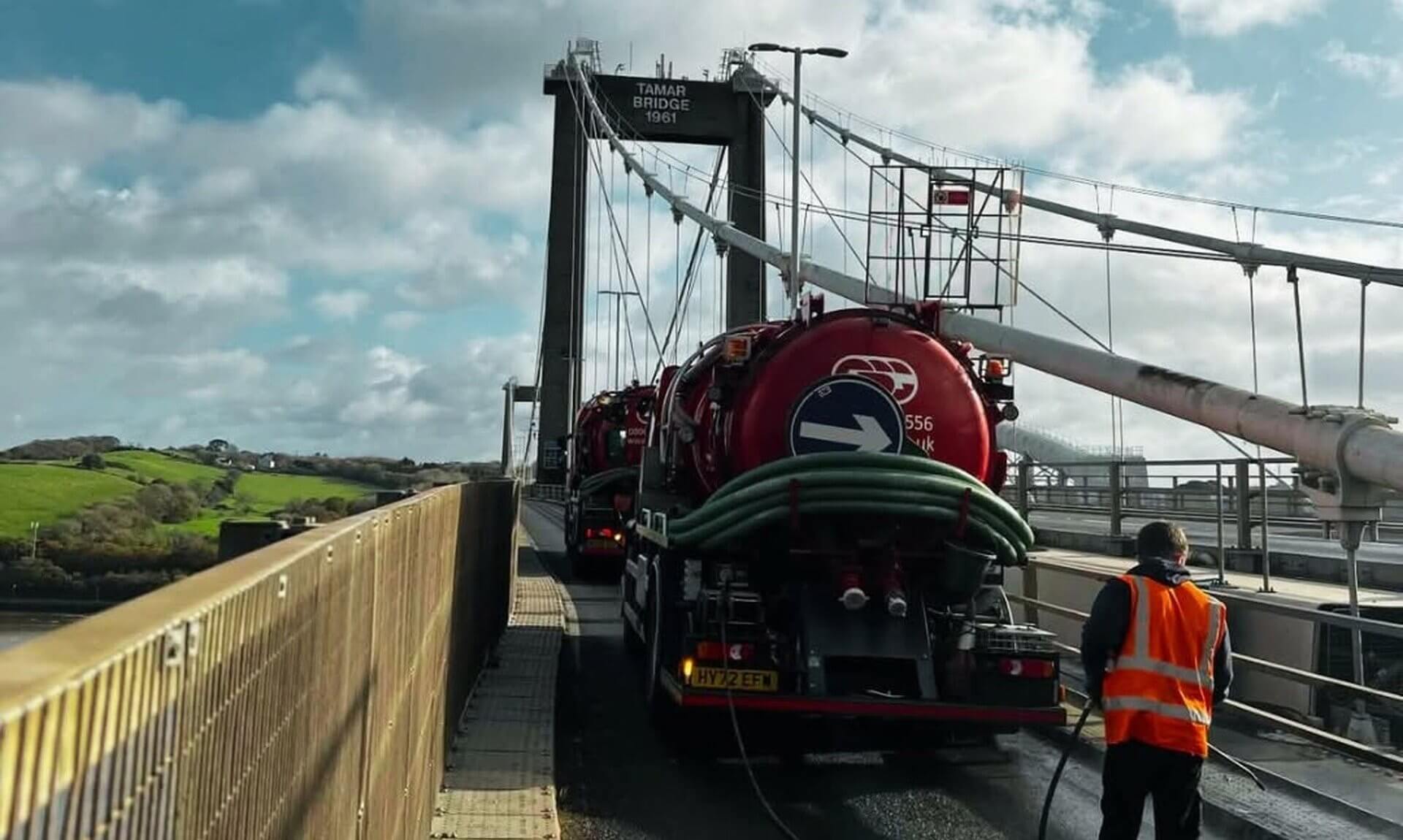 Drain cleansing tankers and a worker in hi-vis on the Tamar Bridge