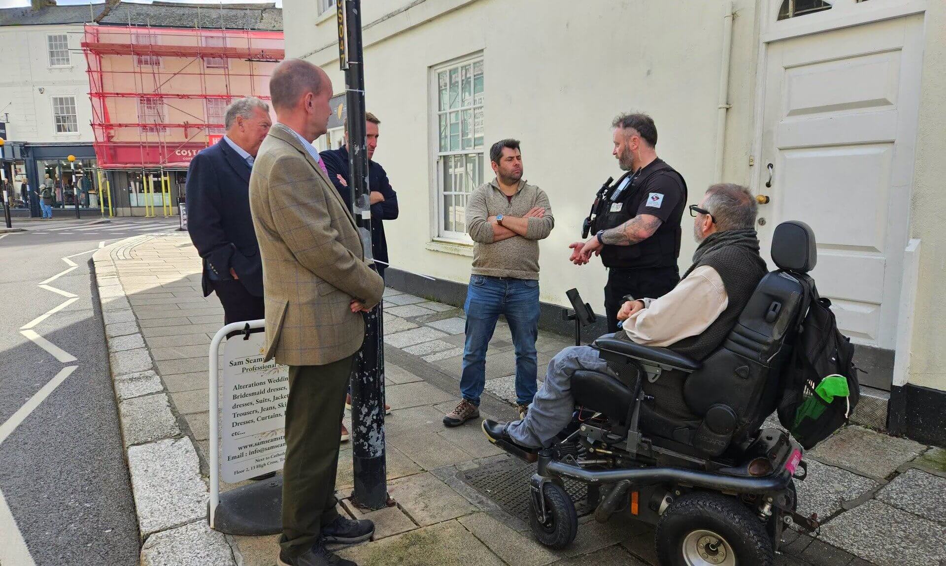 Councillors and business representatives talking with a Truro Ranger on a city-centre street in Truro