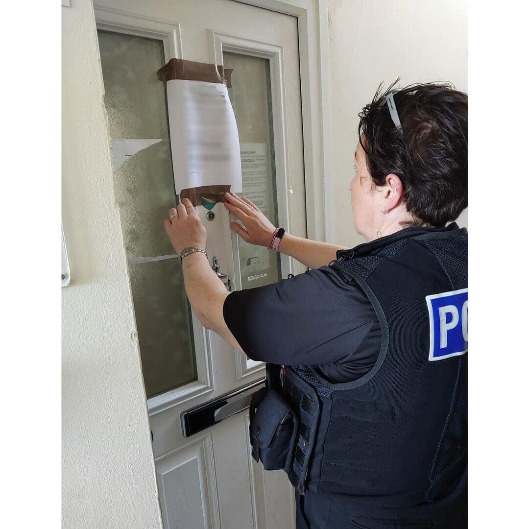 An officer puts up a closure order notice in Truro.