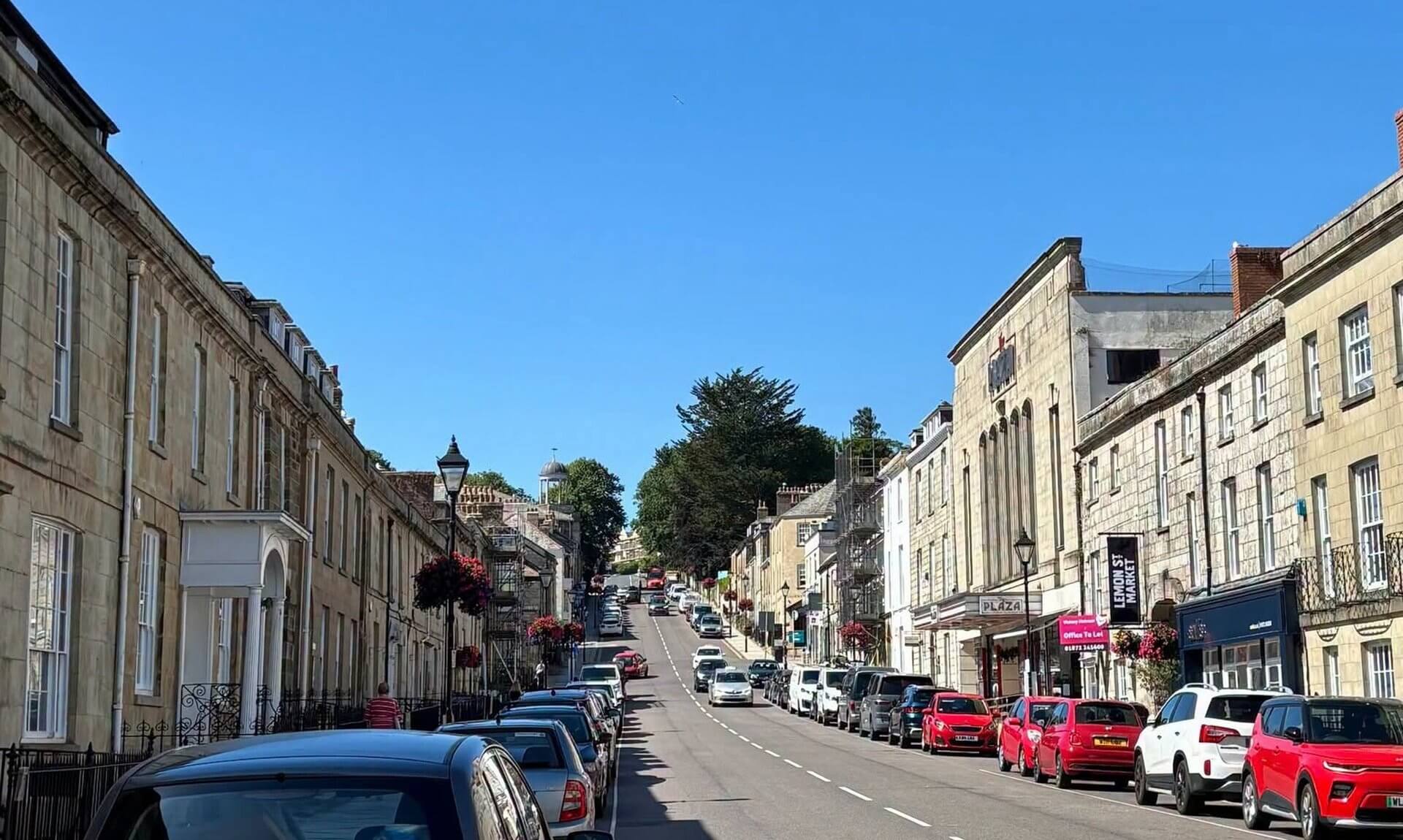 Cars parked on both sides of Lemon Street in Truro under a clear blue sky