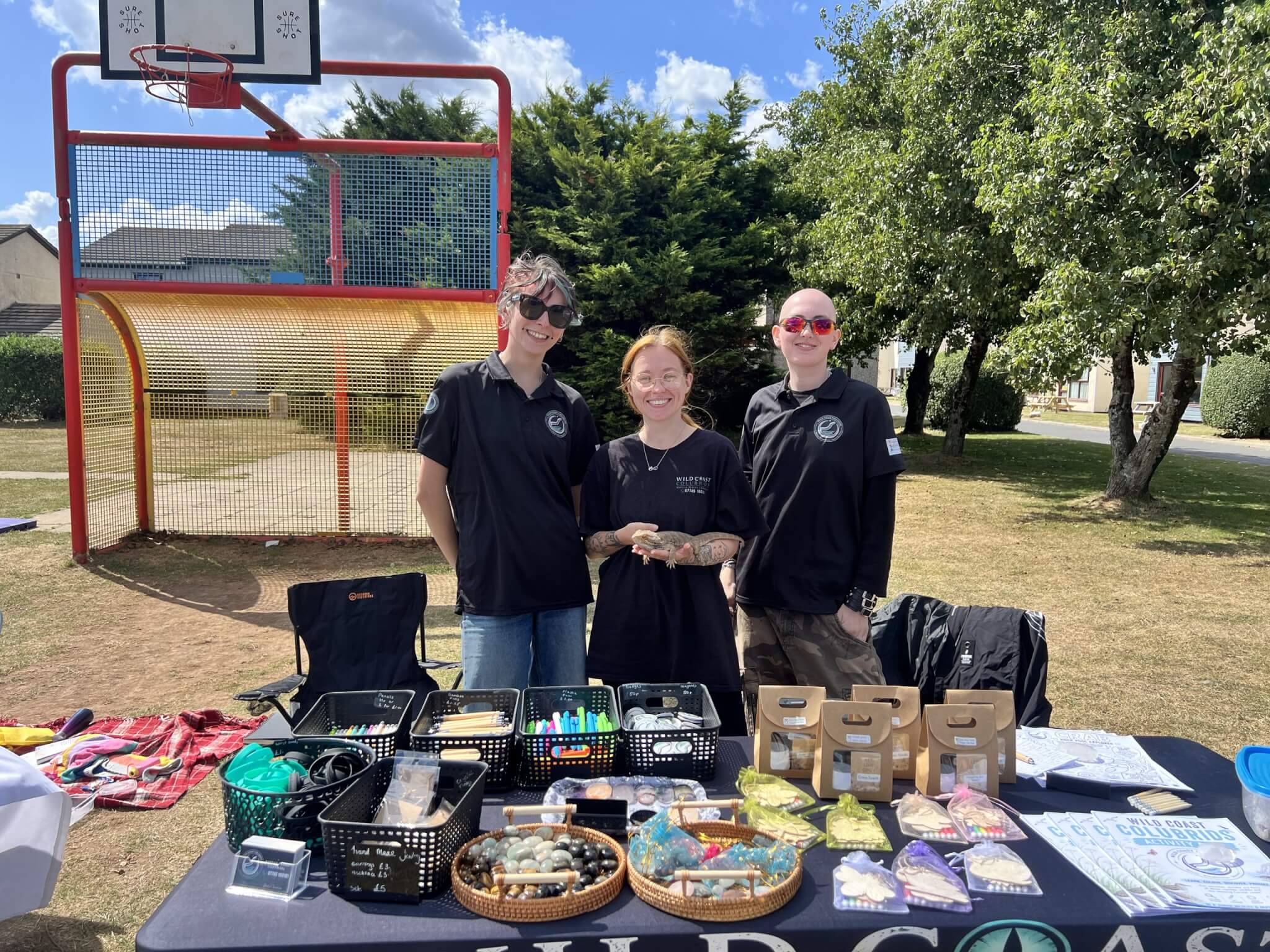 Three volunteers behind a Wild Coast Colubrids stall at an outdoor event
