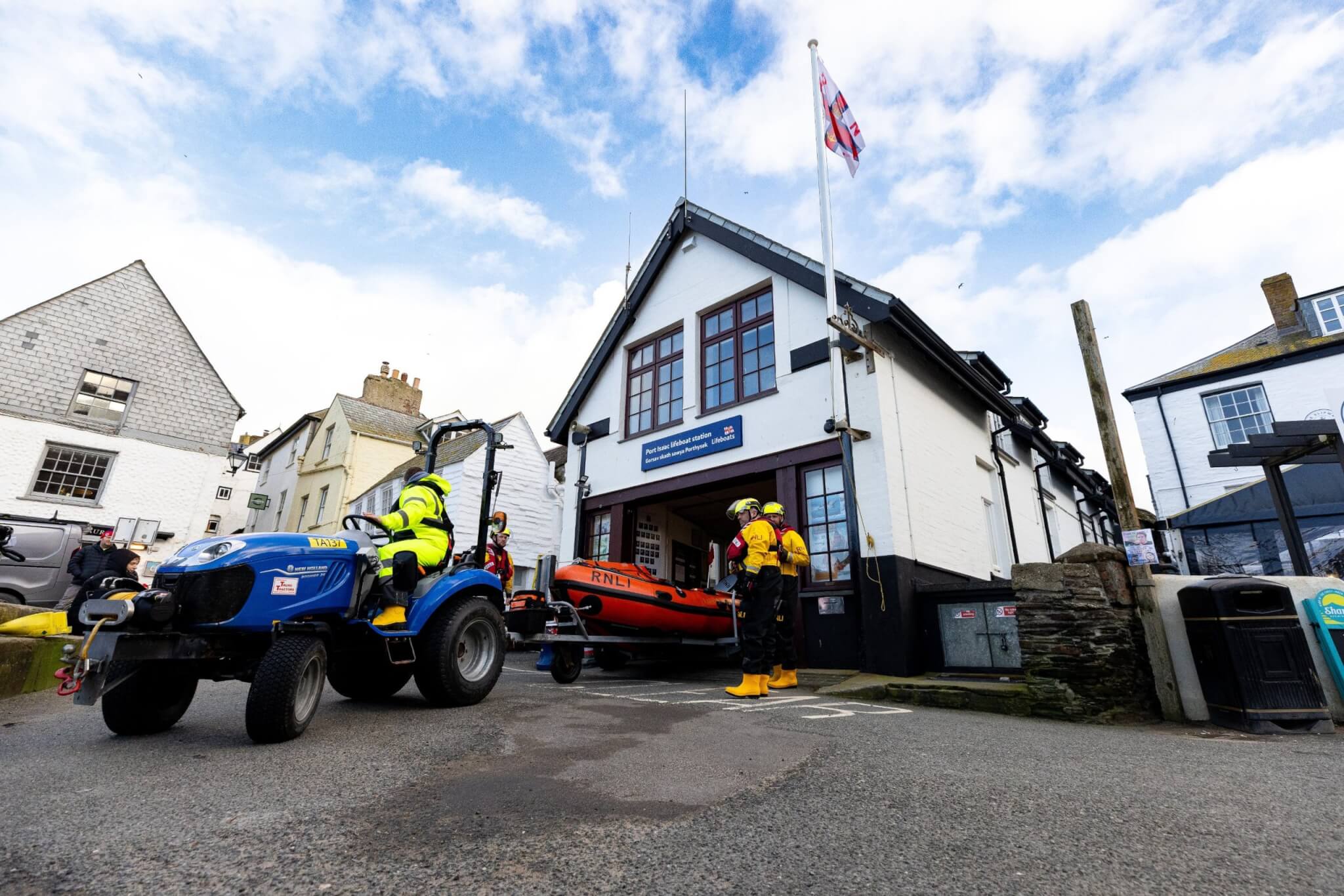 Port Isaac RNLI crew bringing the D-class lifeboat out of the station by tractor