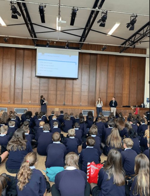 An assembly in the hall at Launceston College with a presentation on screen
