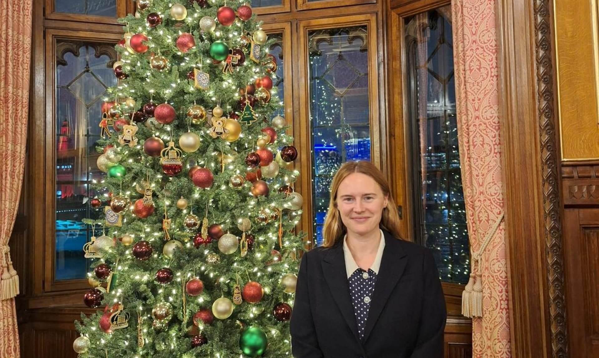 Anna Gelderd MP standing next to a decorated Christmas tree