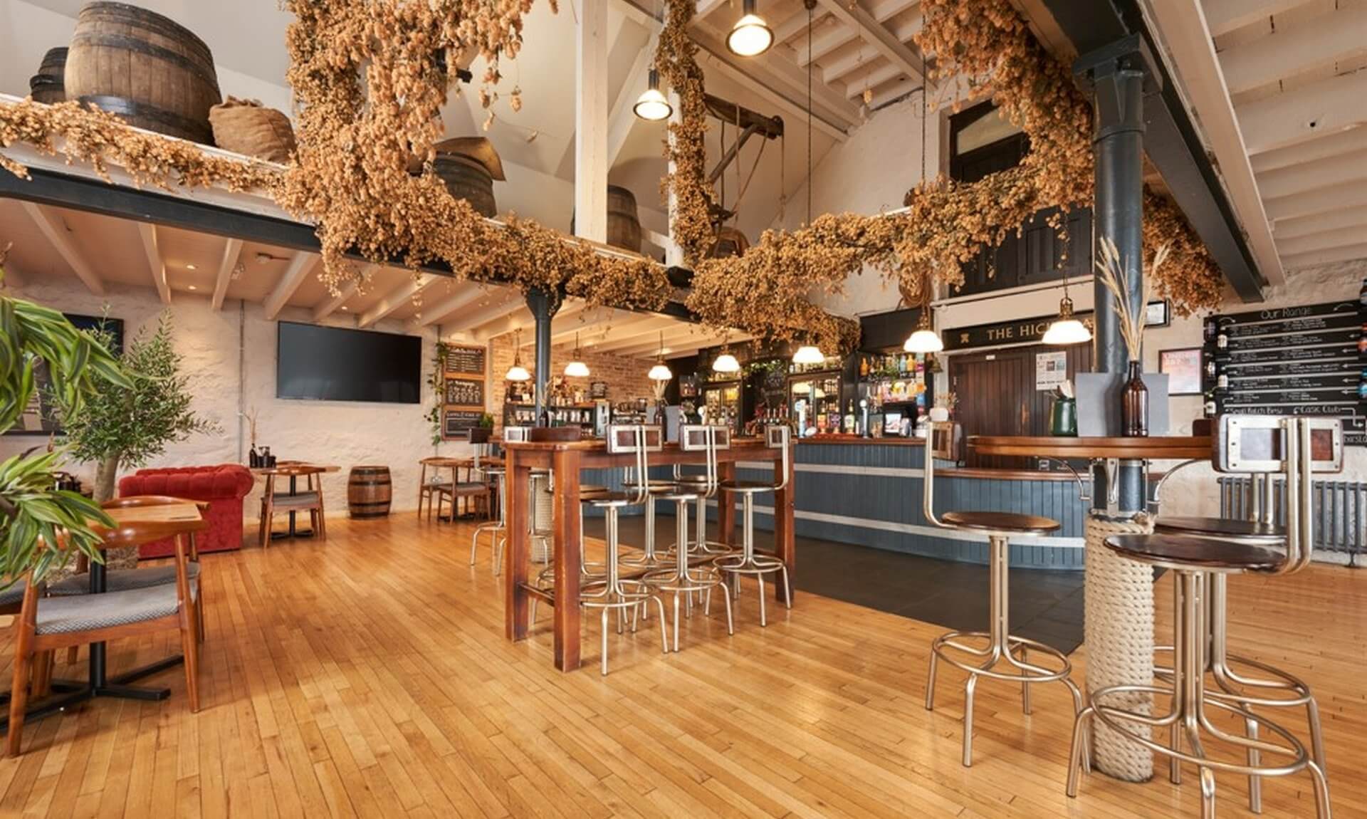 Inside the Hicks Bar at St Austell Brewery, with dried hops hanging from the beams