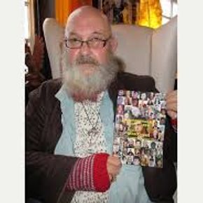 Man holding a book with a cover of photographed faces