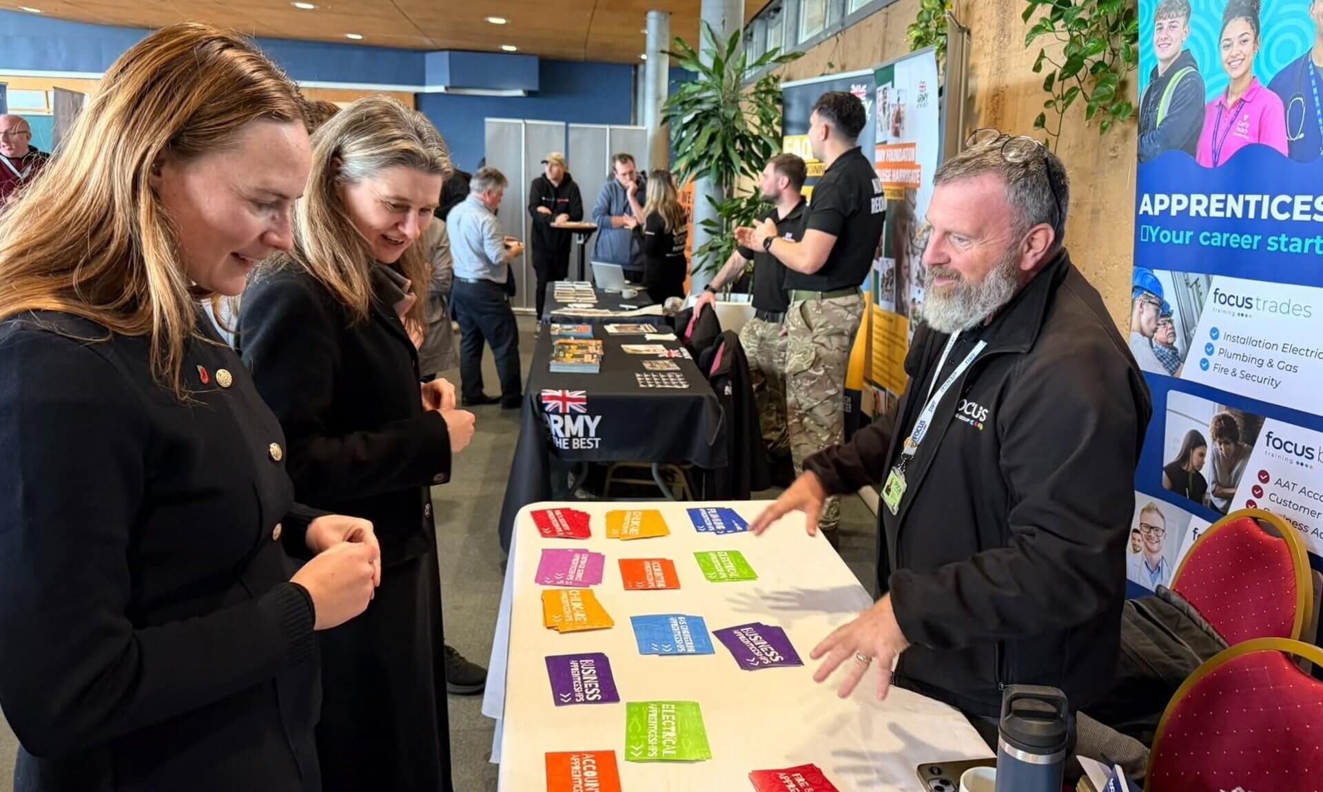 MPs Anna Gelderd and Jayne Kirkham looking at apprenticeship leaflets on a training stand at Cornwall's Jobs Fair, Eden Project