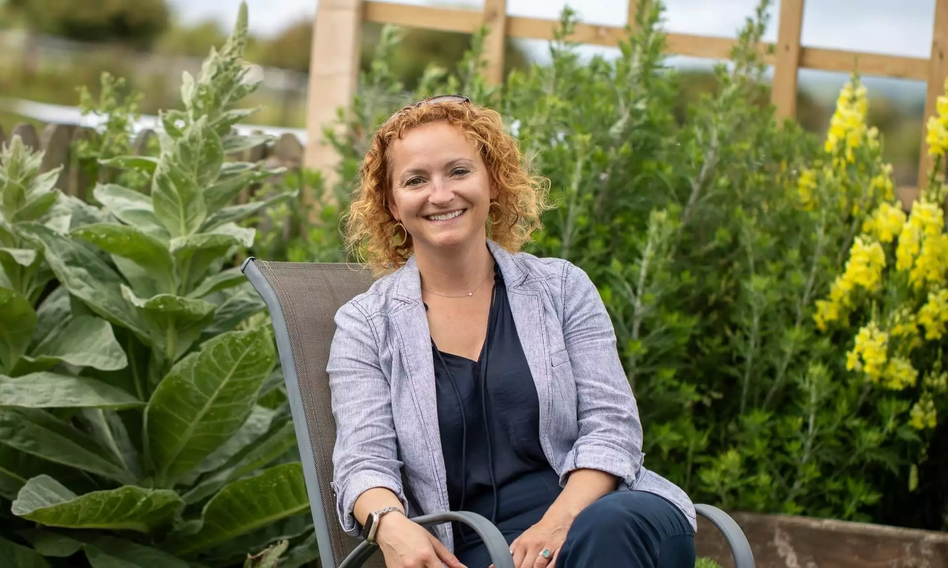 Emma Rowse sitting in a garden chair, smiling