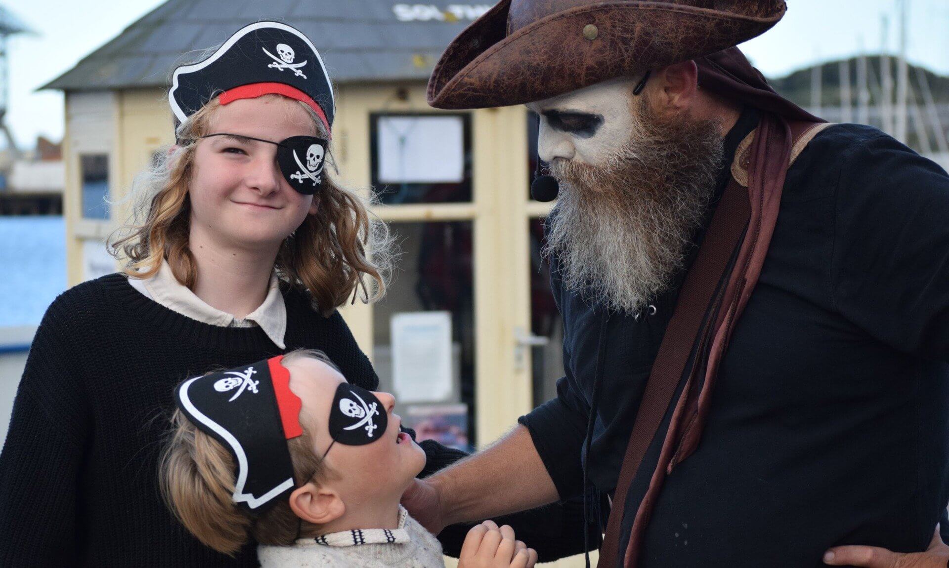 Children in pirate hats and eye patches with a costumed pirate guide in Falmouth