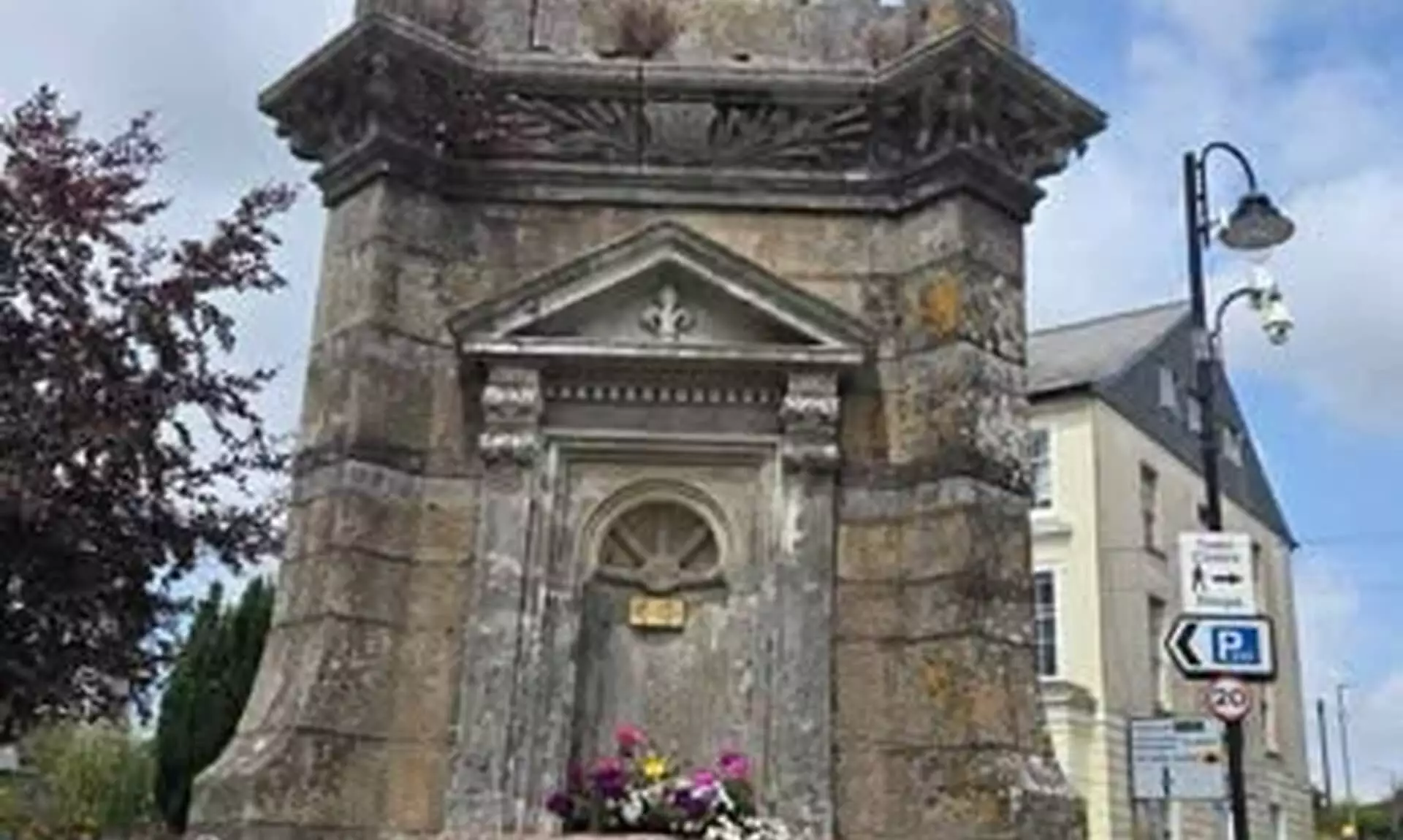 The Fountain on Barras Street in Liskeard, a stone drinking fountain with flower planters