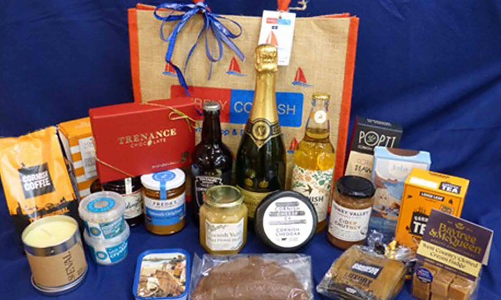 RNLI summer raffle hamper of Cornish food and drink in front of a Purely Cornish jute bag