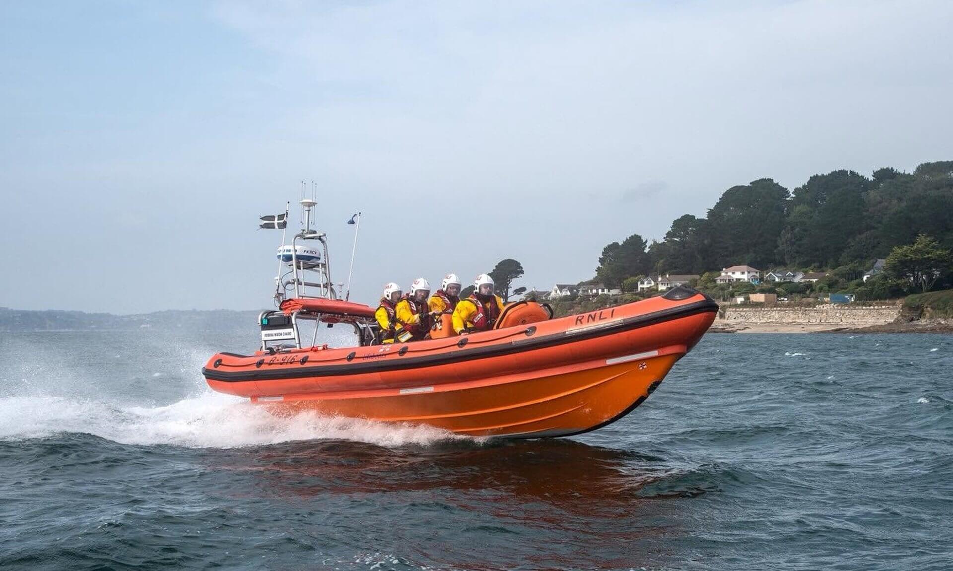 Falmouth RNLI Atlantic 85 inshore lifeboat at speed with four crew on board