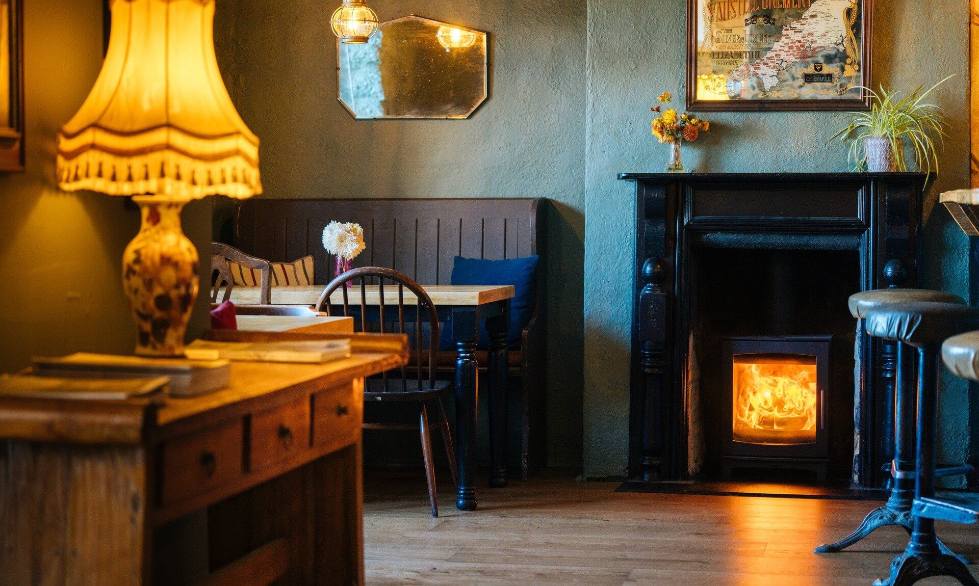 Lounge at the Red Lion in Newlyn with a lit log burner and table lamp
