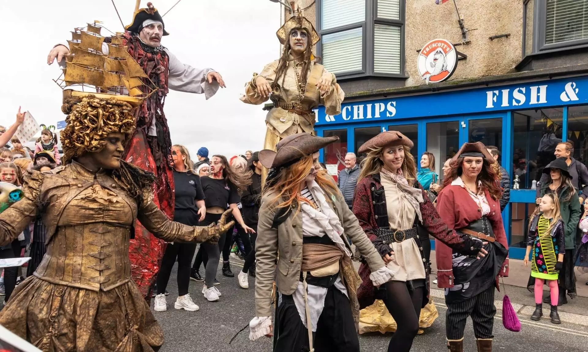 Stilt walkers and costumed pirates in the Newquay Zombie Crawl procession