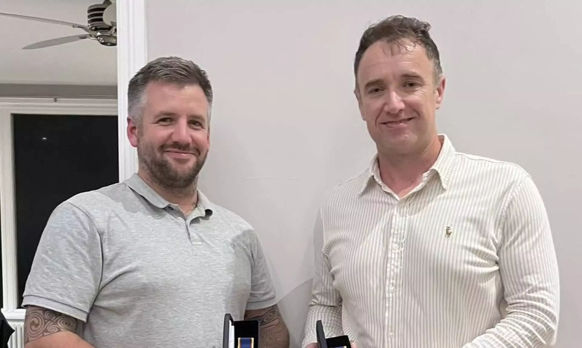 Padstow RNLI volunteer crew Tom Norfolk and Ross McBurnie holding their 20 year long service medals