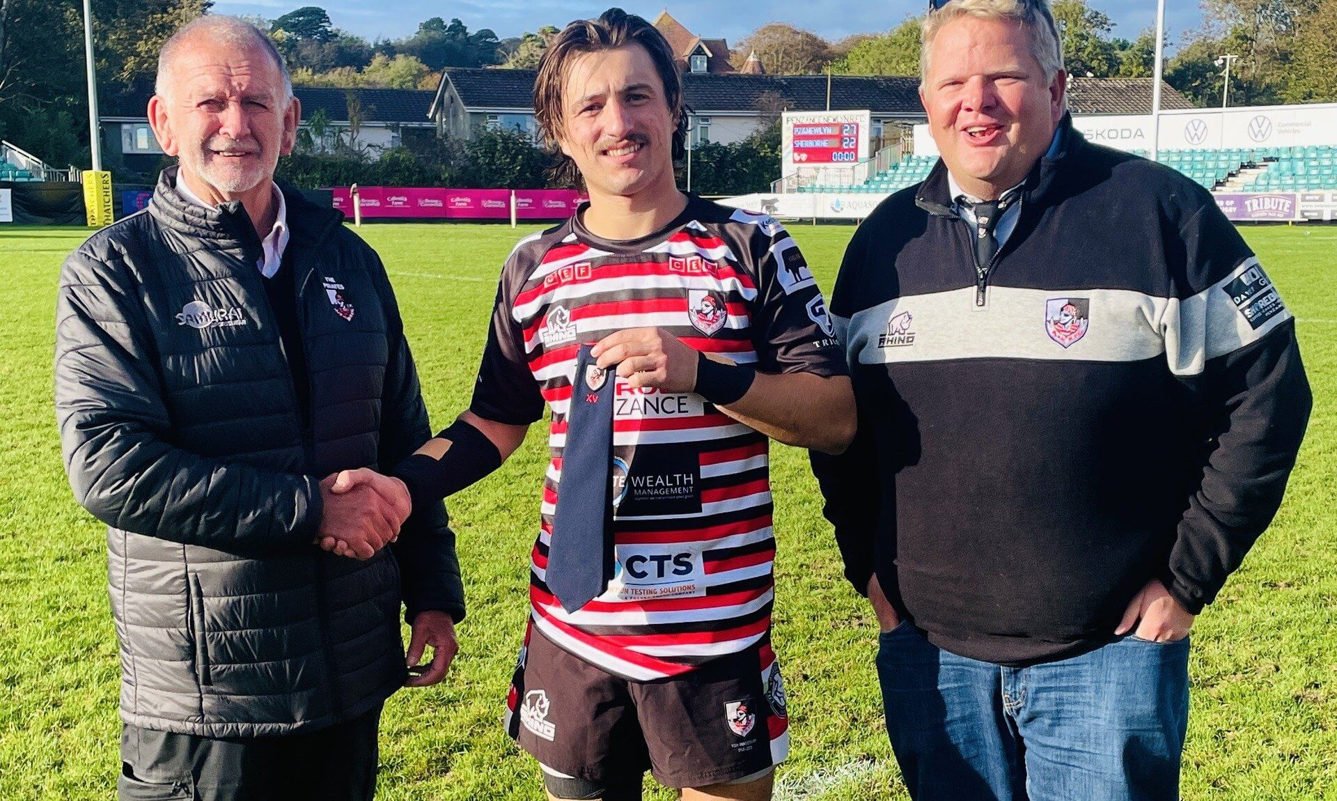 Dan Rhys Evans receives his 100 games tie from Pirates' President Phil Westren, with club Chairman Peter Whyte