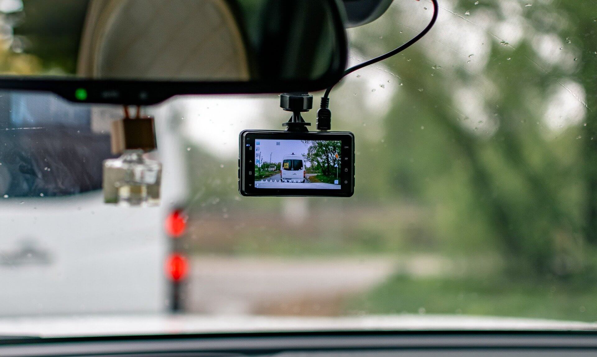 Dashcam mounted on a car windscreen in the rain