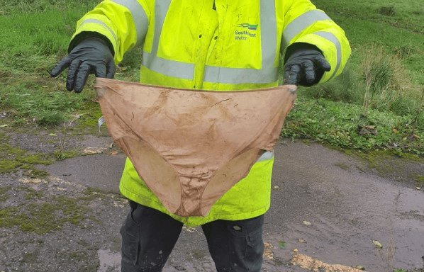 South West Water worker holding a pair of pants found in a pipe in Exeter