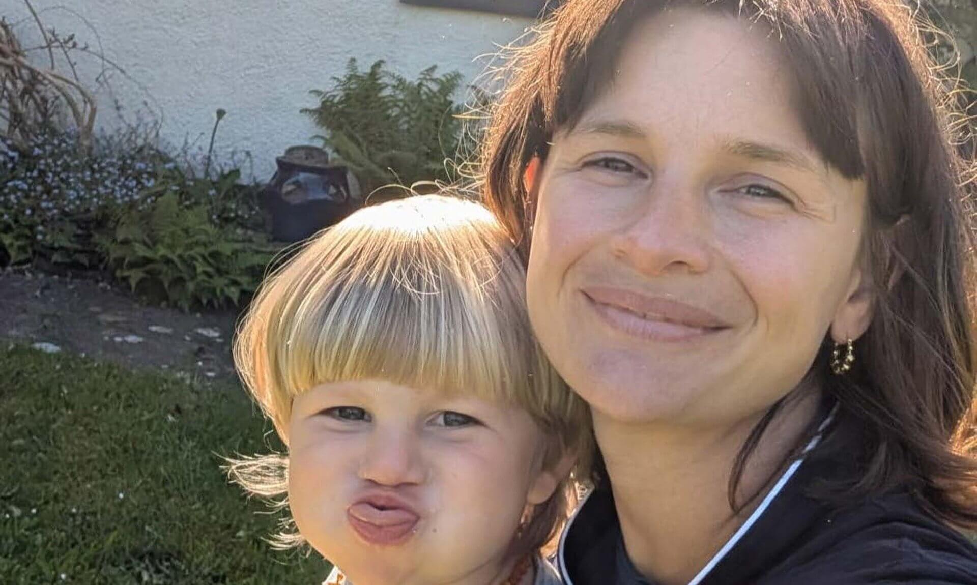 St Austell mum Em smiling in a garden with her youngest son